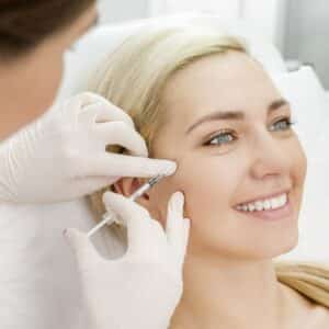 The doctor injects fillers for midage white girl