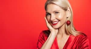 Mature woman with beautiful, glowing skin, wearing ornament earrings for a holiday party