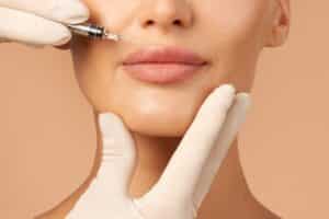 Close-up image of woman's lips as medical provider administers RHA dermal fillers